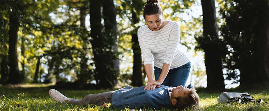 Frau übt Herzdruckmassage aus.