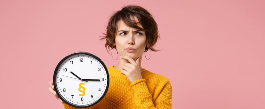 Frau zeigt Uhr mit Paragraphenzeichen und schaut fragend